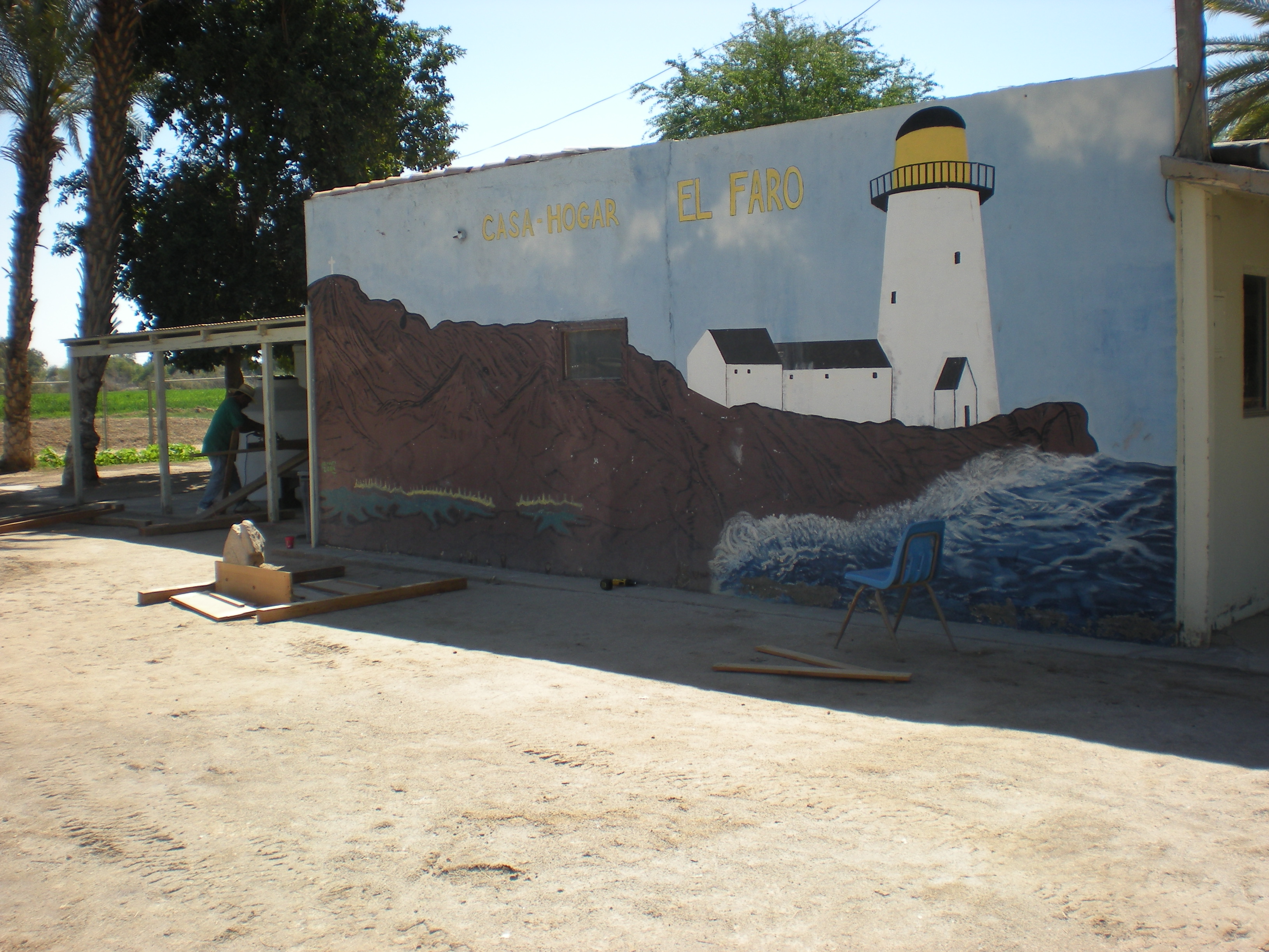 A wall of the orphanage with a mural of a lighthouse.